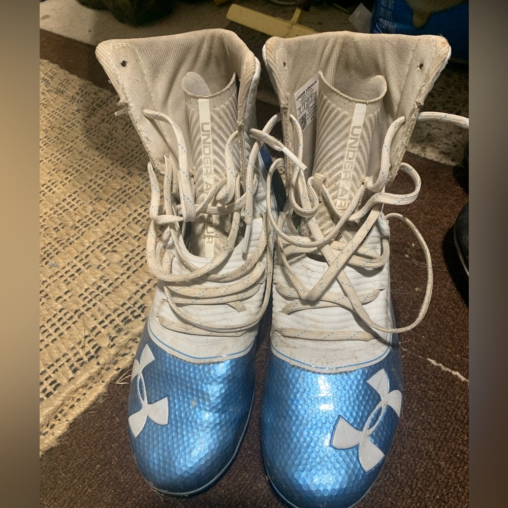 Men’s under armor white and blue cleats.